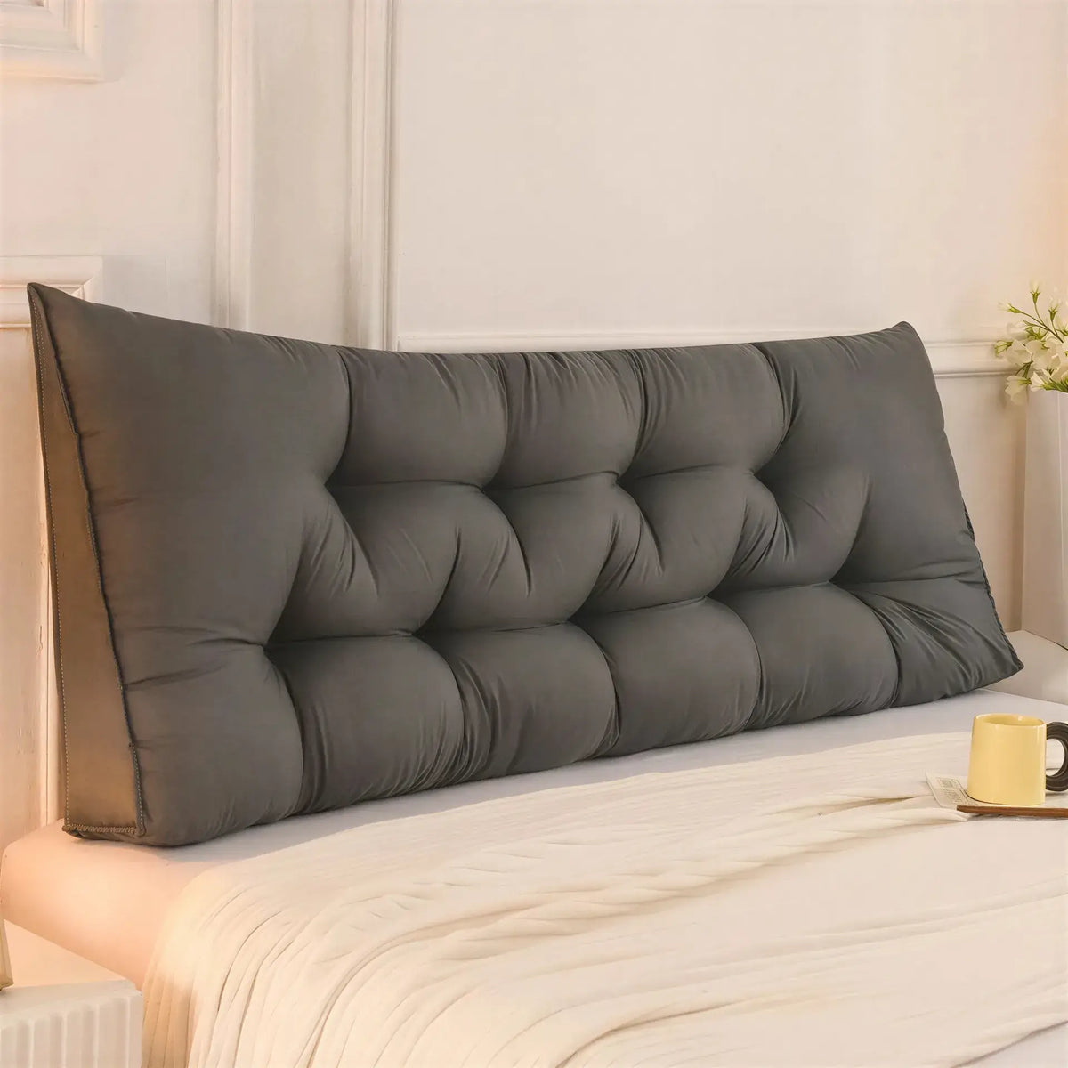 Zora triangular wedge headboard cushion on bed, providing comfortable support for beds and sofas in a modern living space.