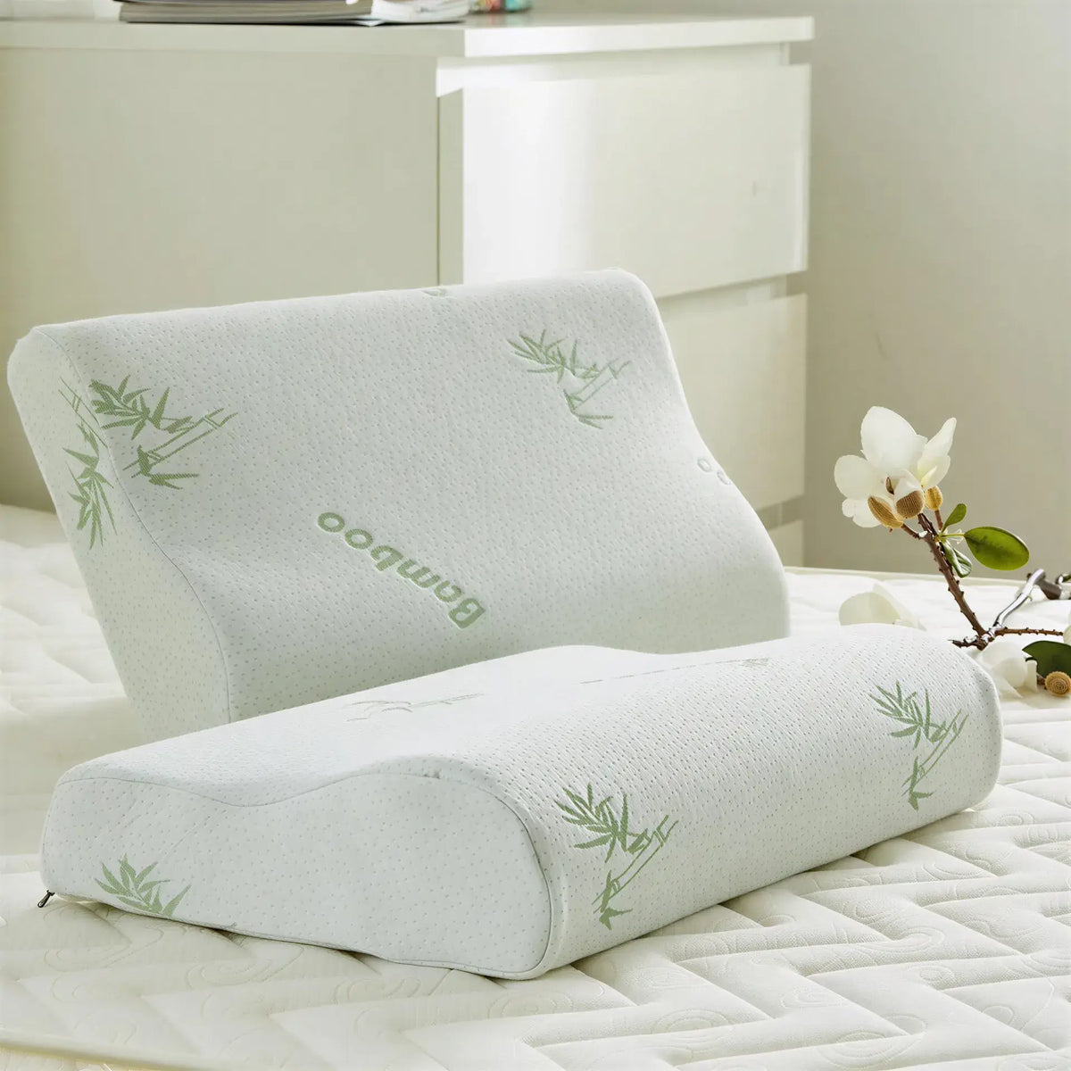 Zora ergonomic memory foam pillow with contoured design for neck support, shown on a bed with soft bedding.