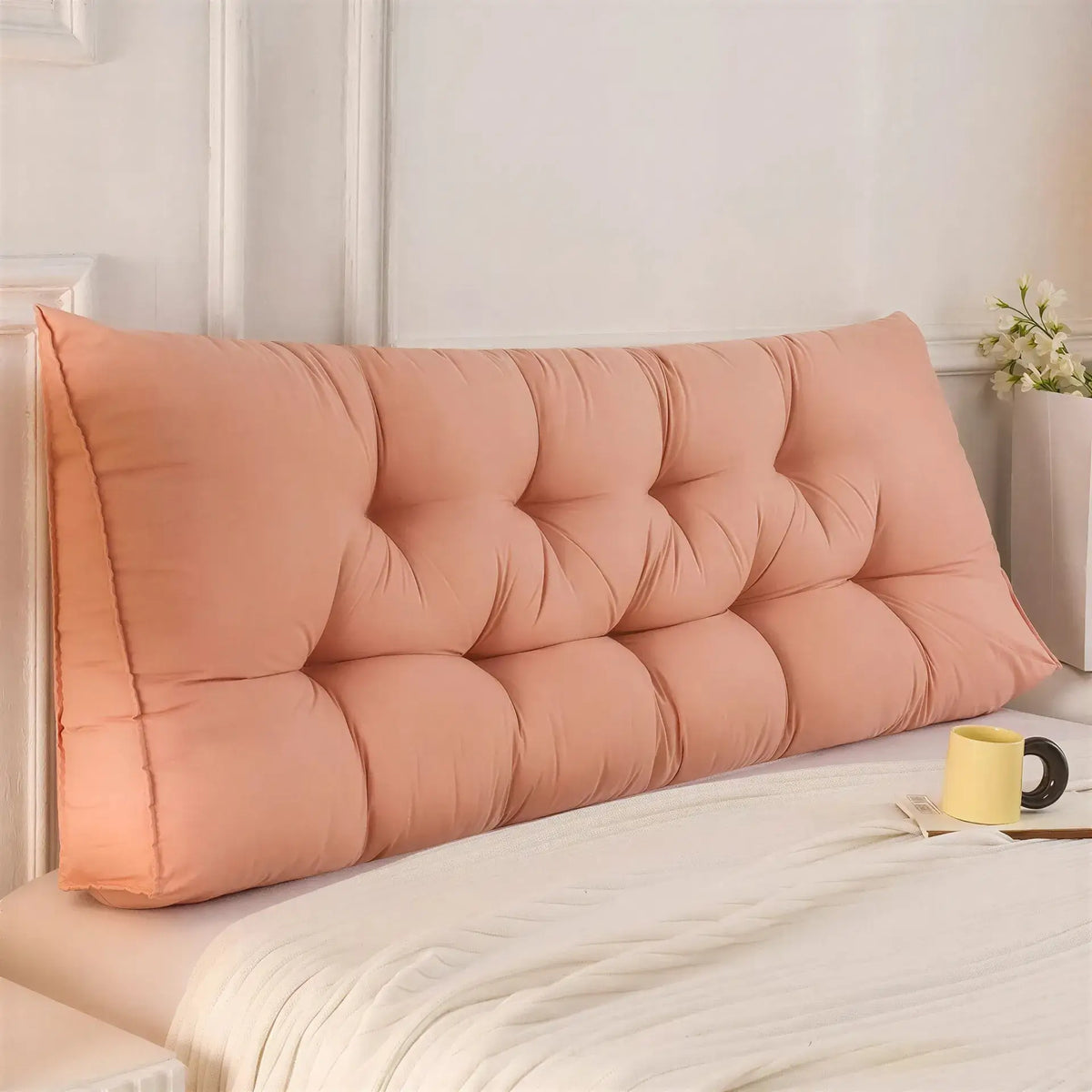 Zora triangular wedge headboard cushion on bed or sofa, providing comfortable support for relaxing or resting.