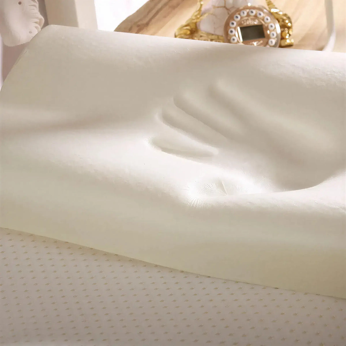 Zora ergonomic memory foam pillow with contoured shape for neck and head support, in white fabric cover.