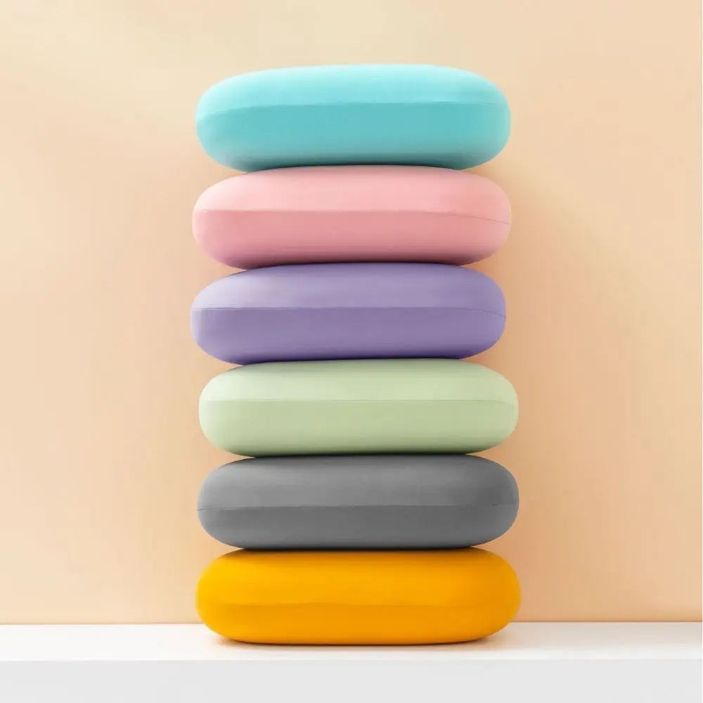 Zora portable macaron-shaped nap pillow for neck support, ideal travel accessory for comfortable rest on the go.