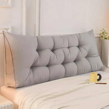 Zora triangular wedge headboard cushion on bed, providing comfortable support for bed and sofa with soft fabric cover.