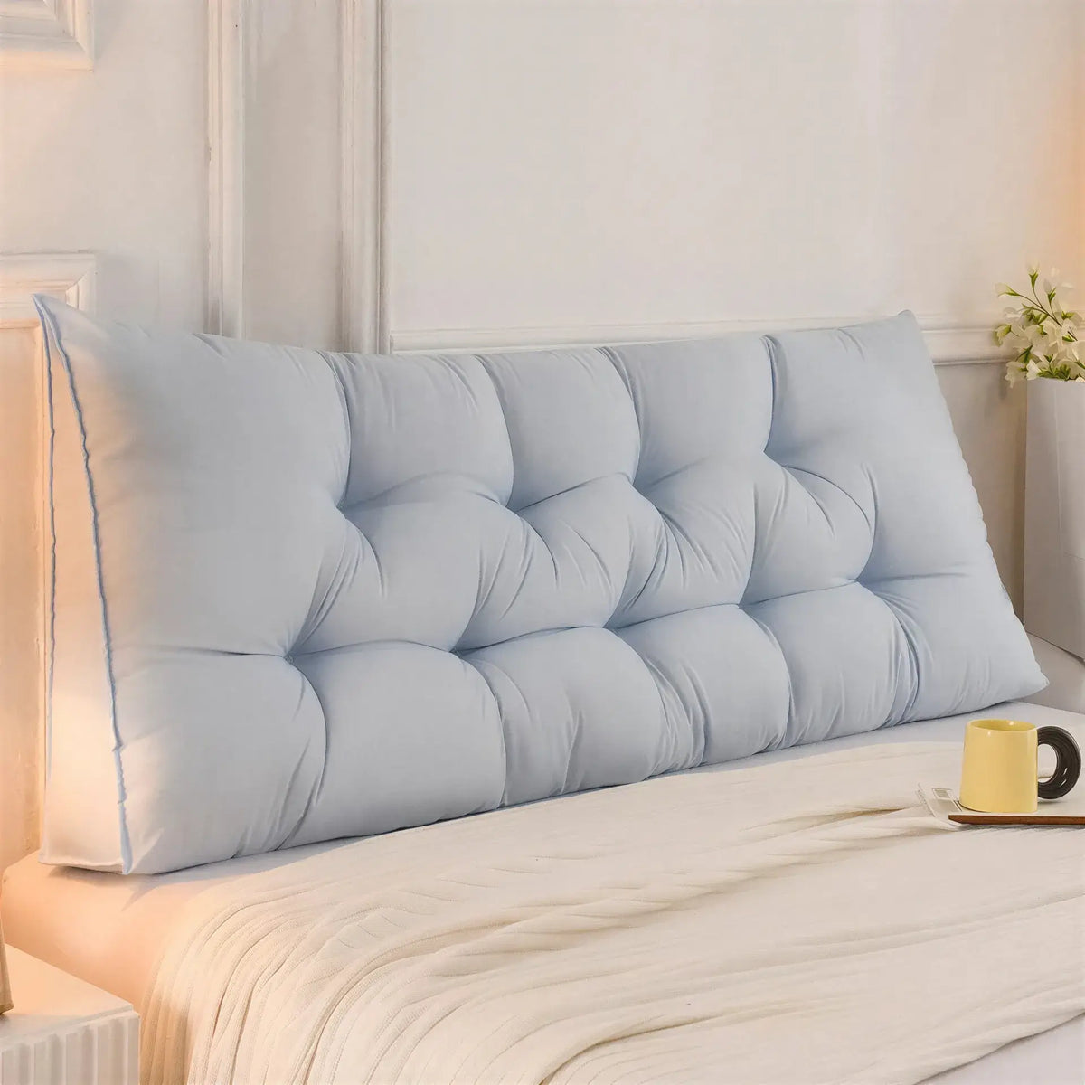 Zora triangular wedge headboard cushion on a bed or sofa, providing comfortable support for bed and sofa use.